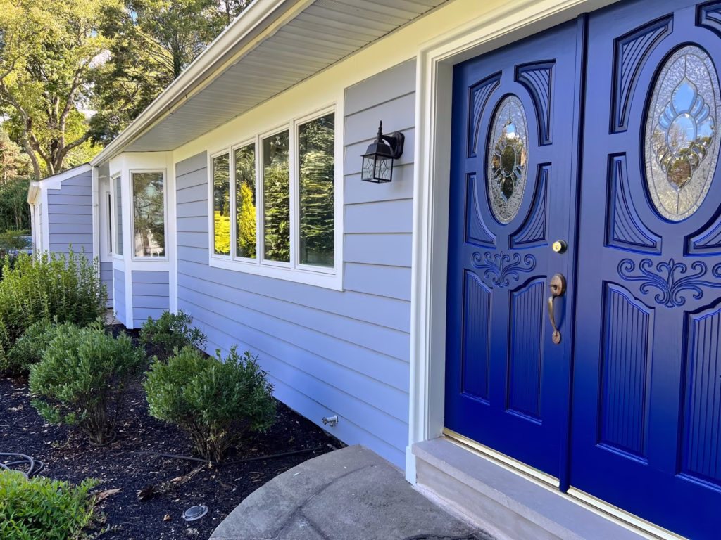 Freshly painted blue front door and siding