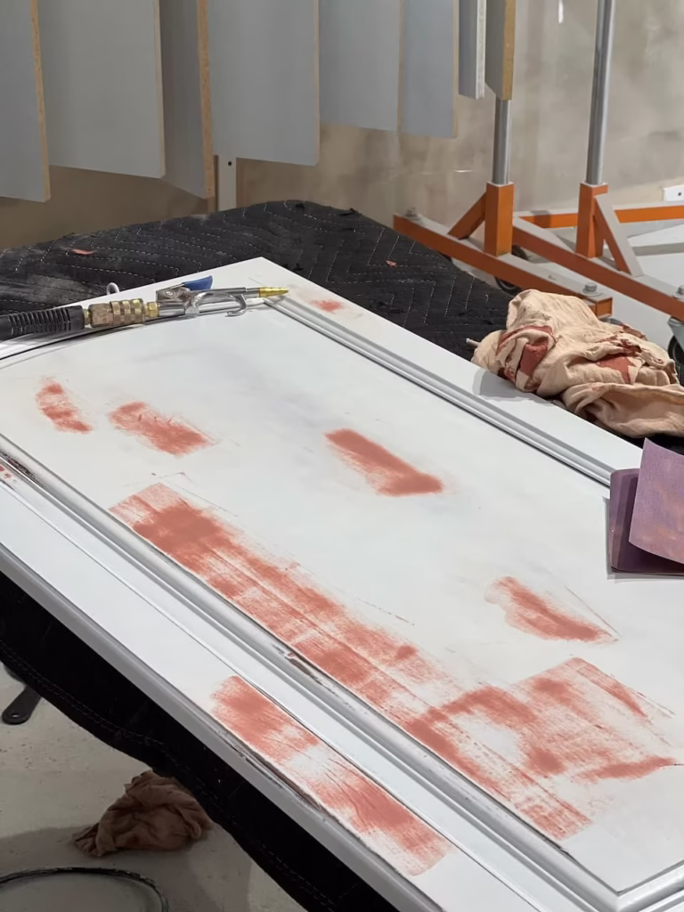 Cabinet door being sanded before painting
